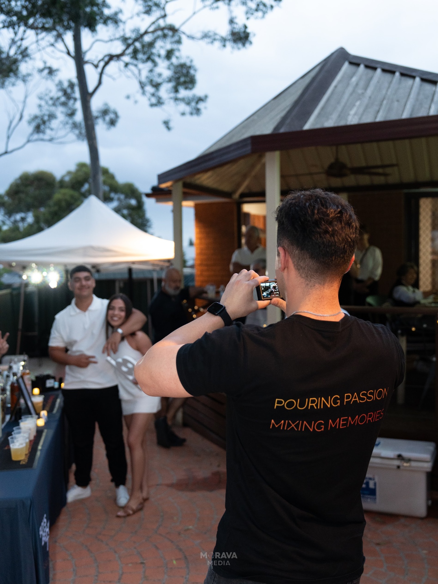 Bartender taking photos of guests with slogan tee